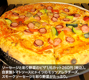 ソーセージと彩り野菜のピザ1/6カット260円(税込)。自家製トマトソースにドイツのモッツアレラチーズ、スモークソーセージと彩り野菜がたっぷり。